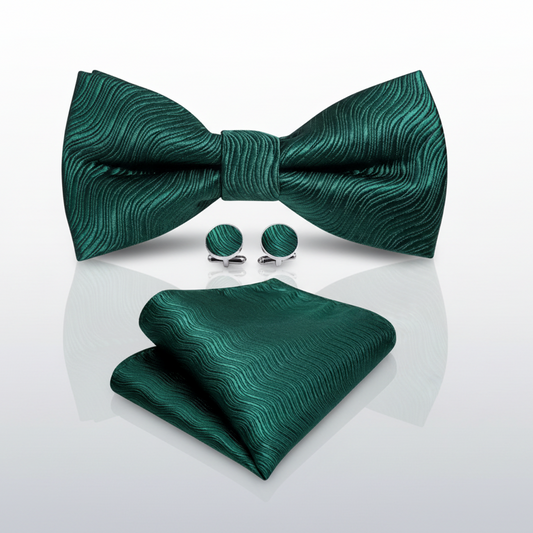A set of green bowtie, pocket square, and cufflinks laid out on a white background.