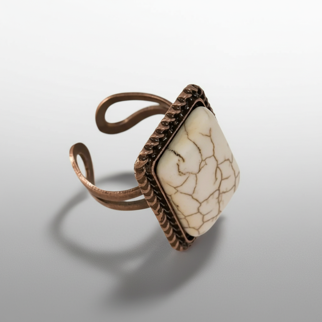 Copper ring with a beige stone on a light gray background