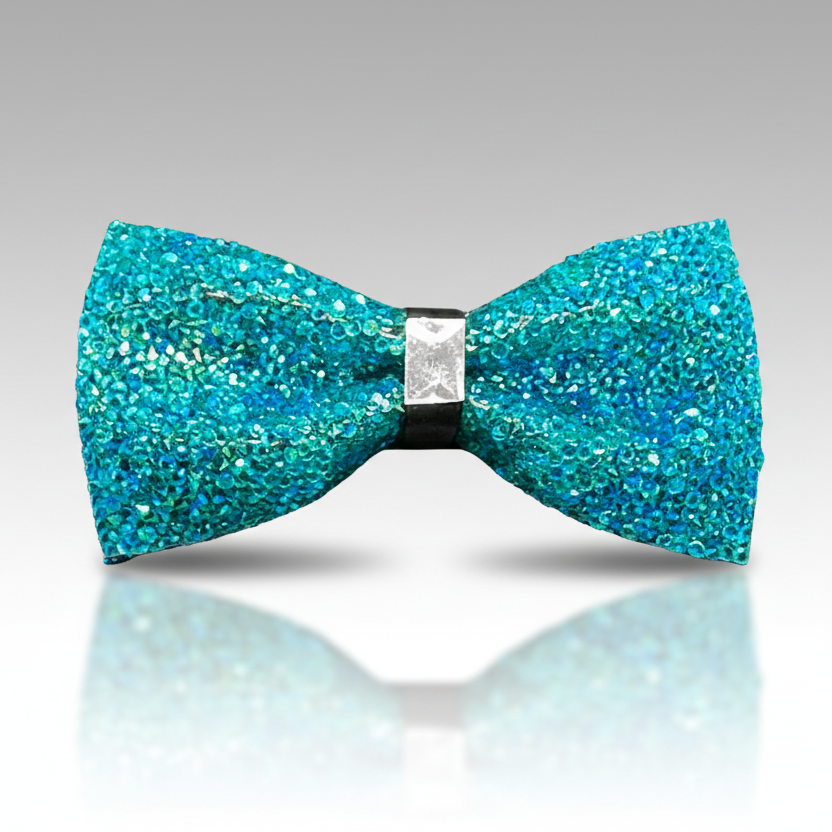 Turquoise glitter bow tie on a reflective surface with a gray background