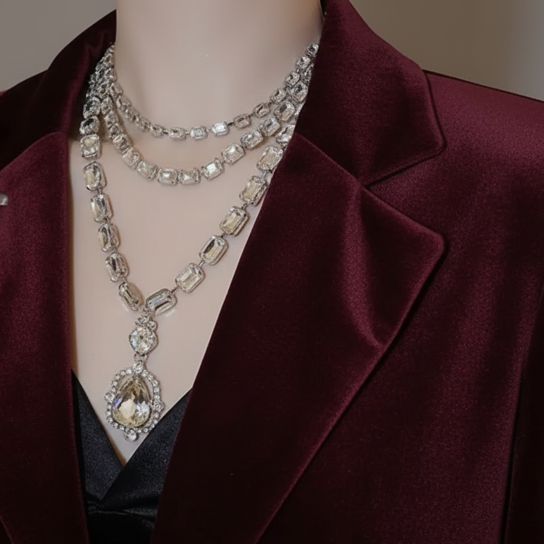Mannequin wearing a burgundy blazer with a sparkling necklace