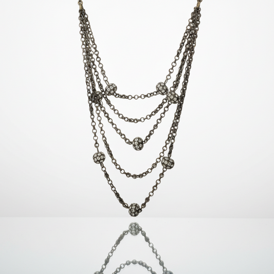 Multi-layered chain necklace with embedded stones on a light gray background