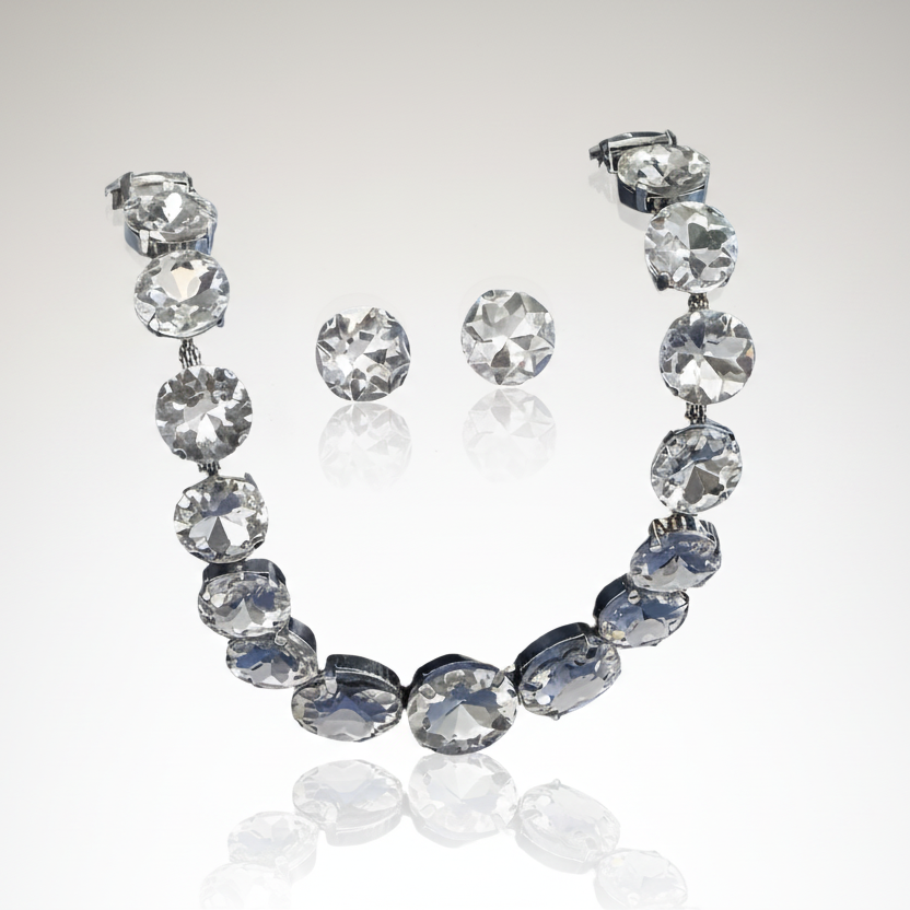 Jewelry set with necklace and earrings featuring large crystals on a reflective surface.