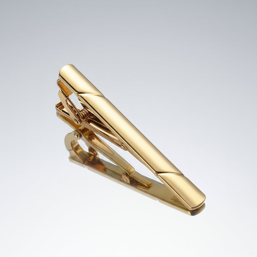 Gold tie clip on a white background