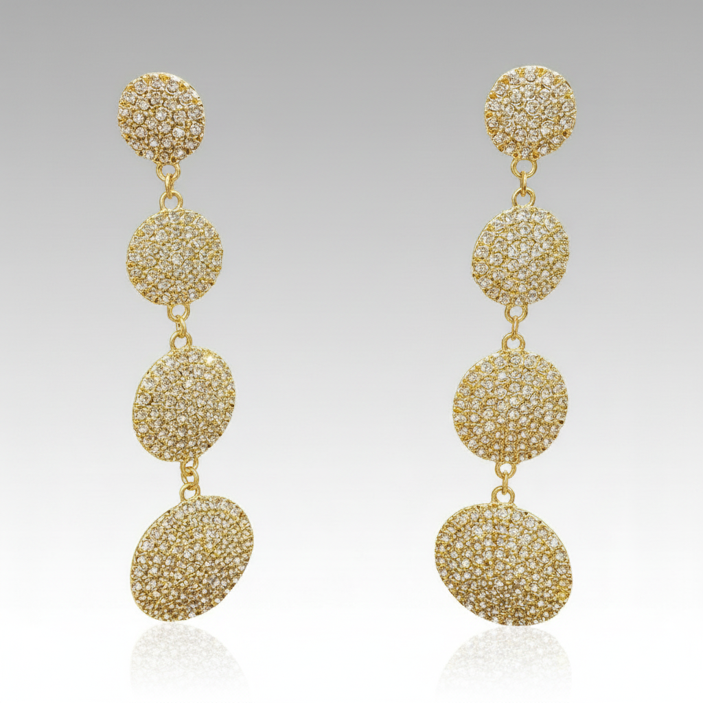 Gold earrings with multiple spherical beads on a gray background