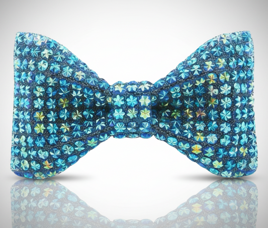 Blue floral patterned bow tie on a reflective surface with a light gray background