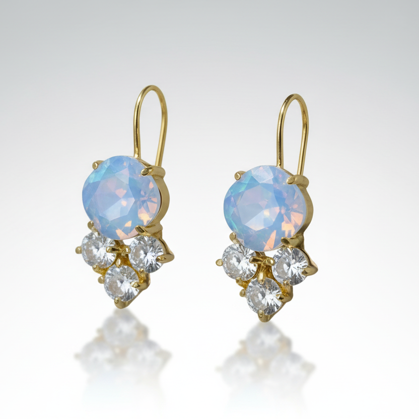 Pair of gold earrings with blue gemstones and clear stones on a gray background