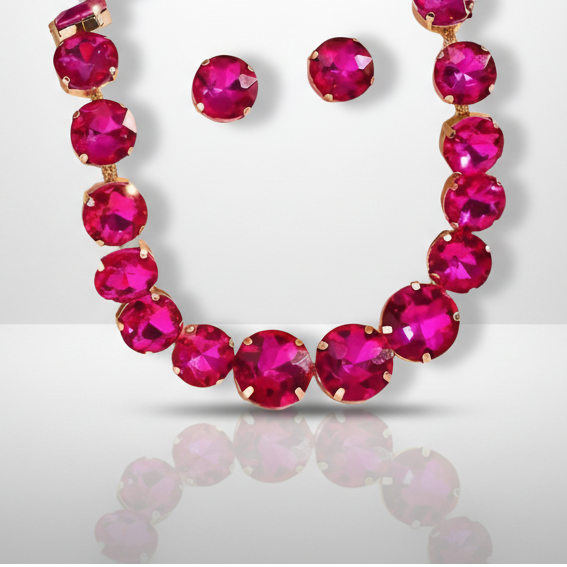Necklace and earrings with bright pink gemstones on a light gray background